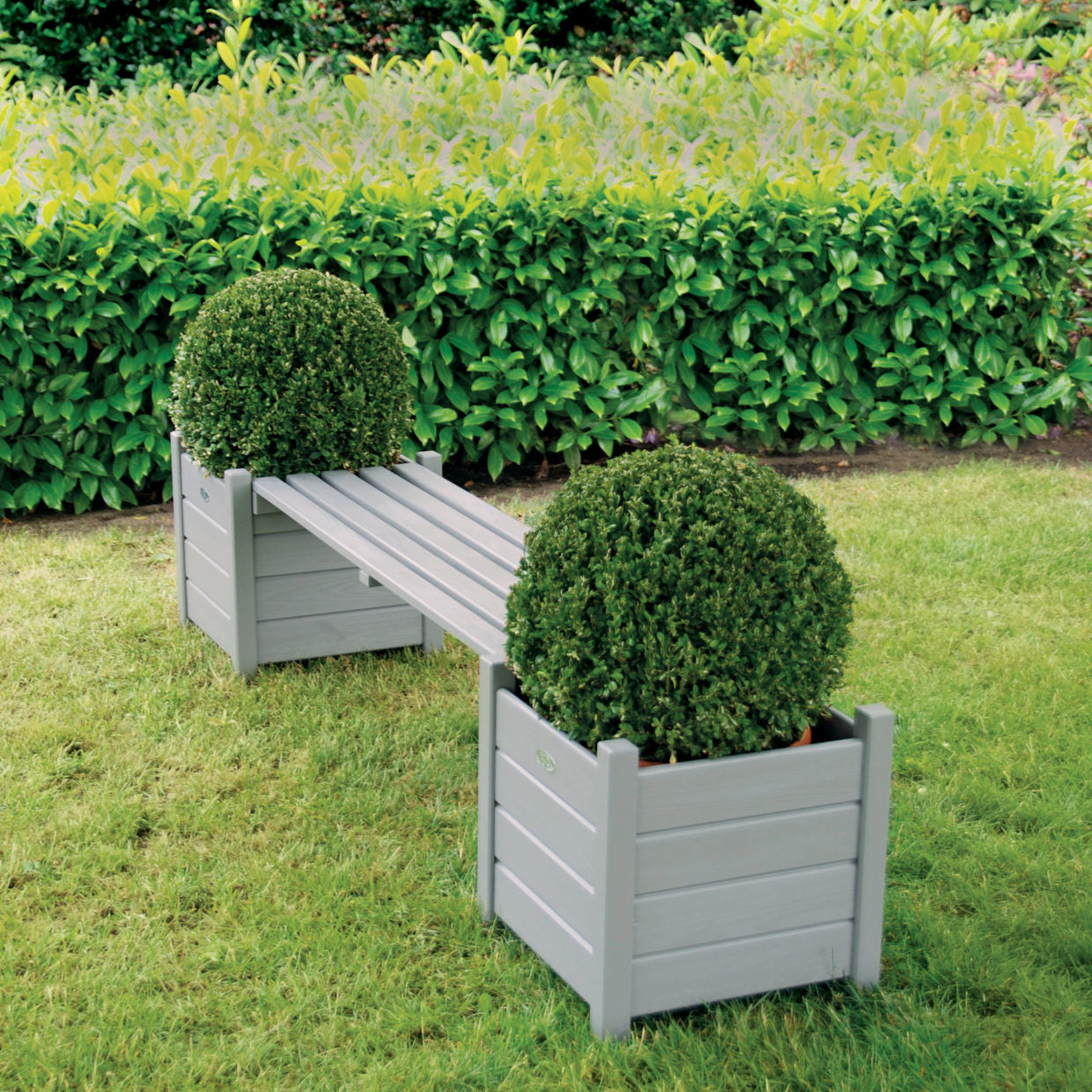 Plantenbakbank met grijs houten kuipen, langsbank met houten latten en bolvormige planten.