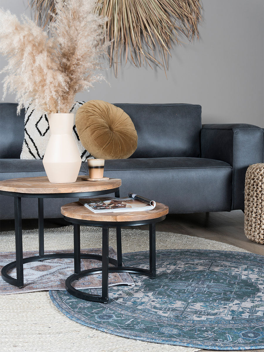 Rond vloerkleed met blauwgroen patroon en beige medaillon op de vloer