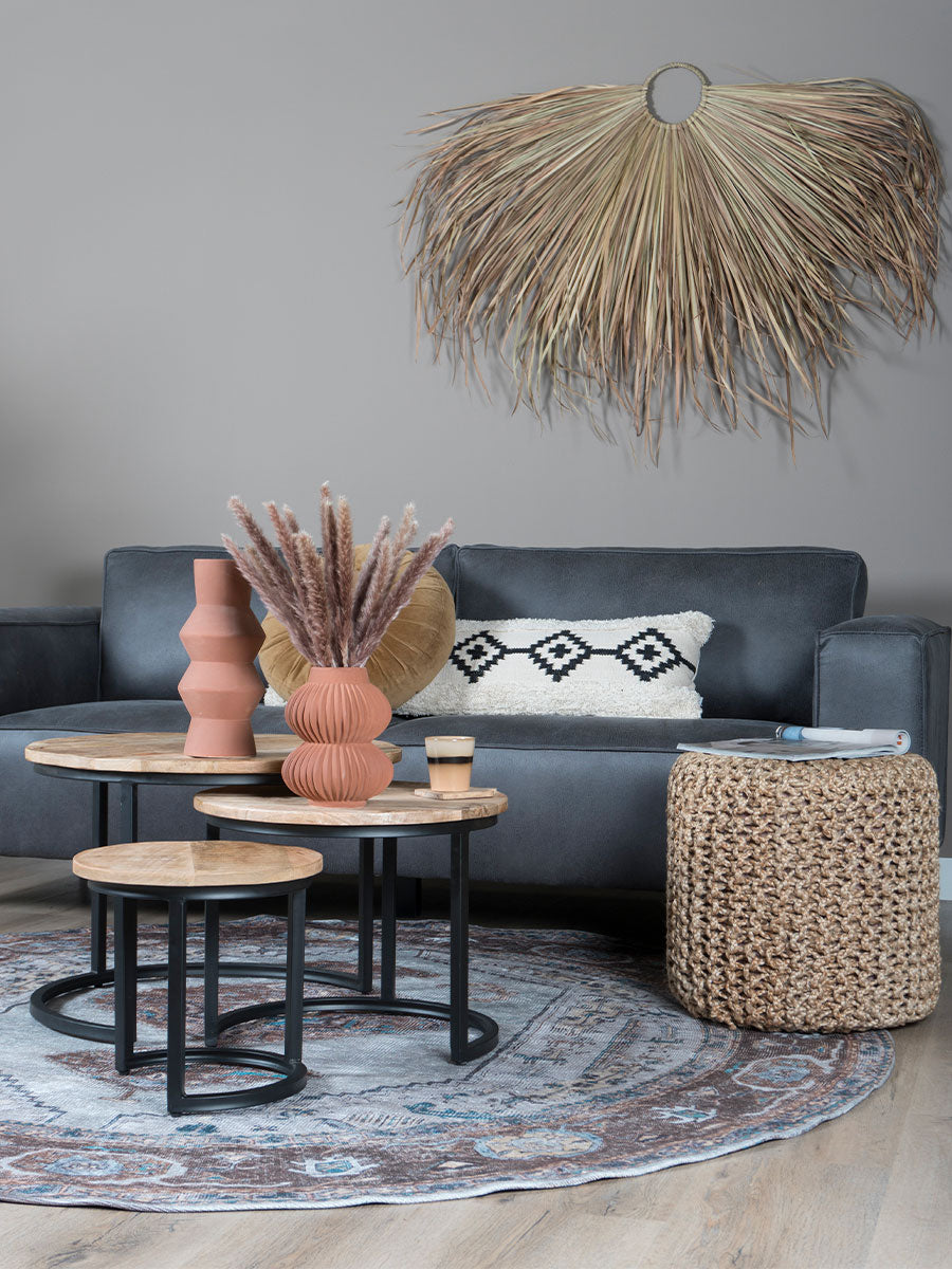 Rond vloerkleed met blauw-bruin geometrisch patroon op de vloer, ø120 cm zichtbaar.