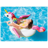Eenhoorn opblaaszwemring met regenboogvleugels en roze rand; persoon ligt erop