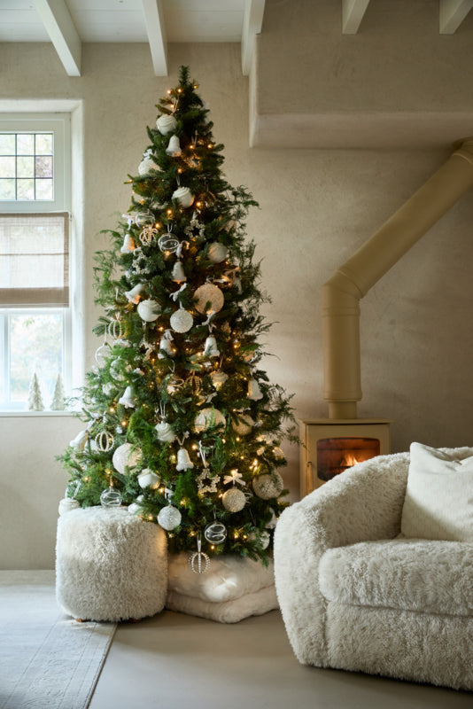 Rivièra Maison Bowery poef in ivoorkleurig pluche naast een kerstboom