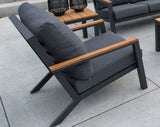 Fauteuil met grijze bekleding en houtlook armleuningen; donkergrijs frame