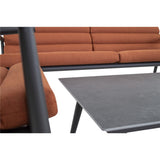 Uitzicht op loungestoel met terracotta kussens naast grijze salontafel.