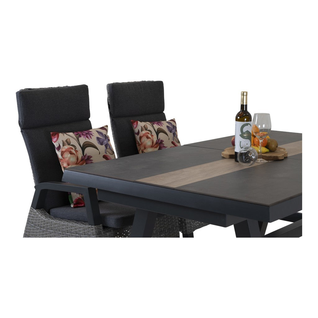 Uittrektafel met grijze stoelen en bloemenkussens, tafelblad met wijnfles en fruit
