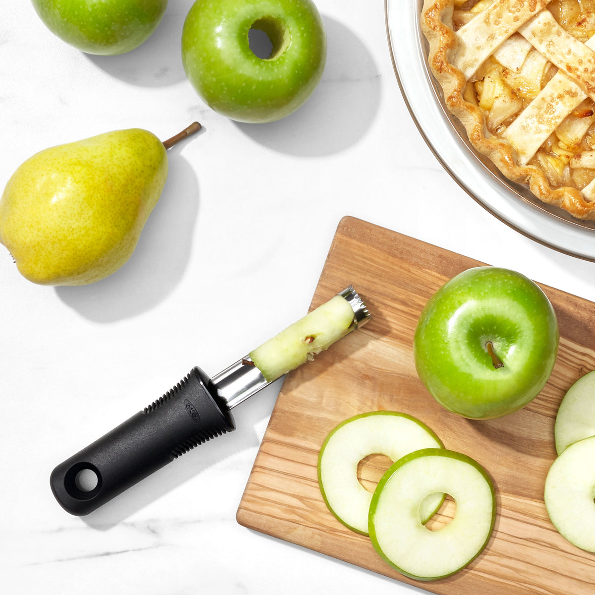Appelboor met zwarte greep op snijplank, boorkern en appelpartjes