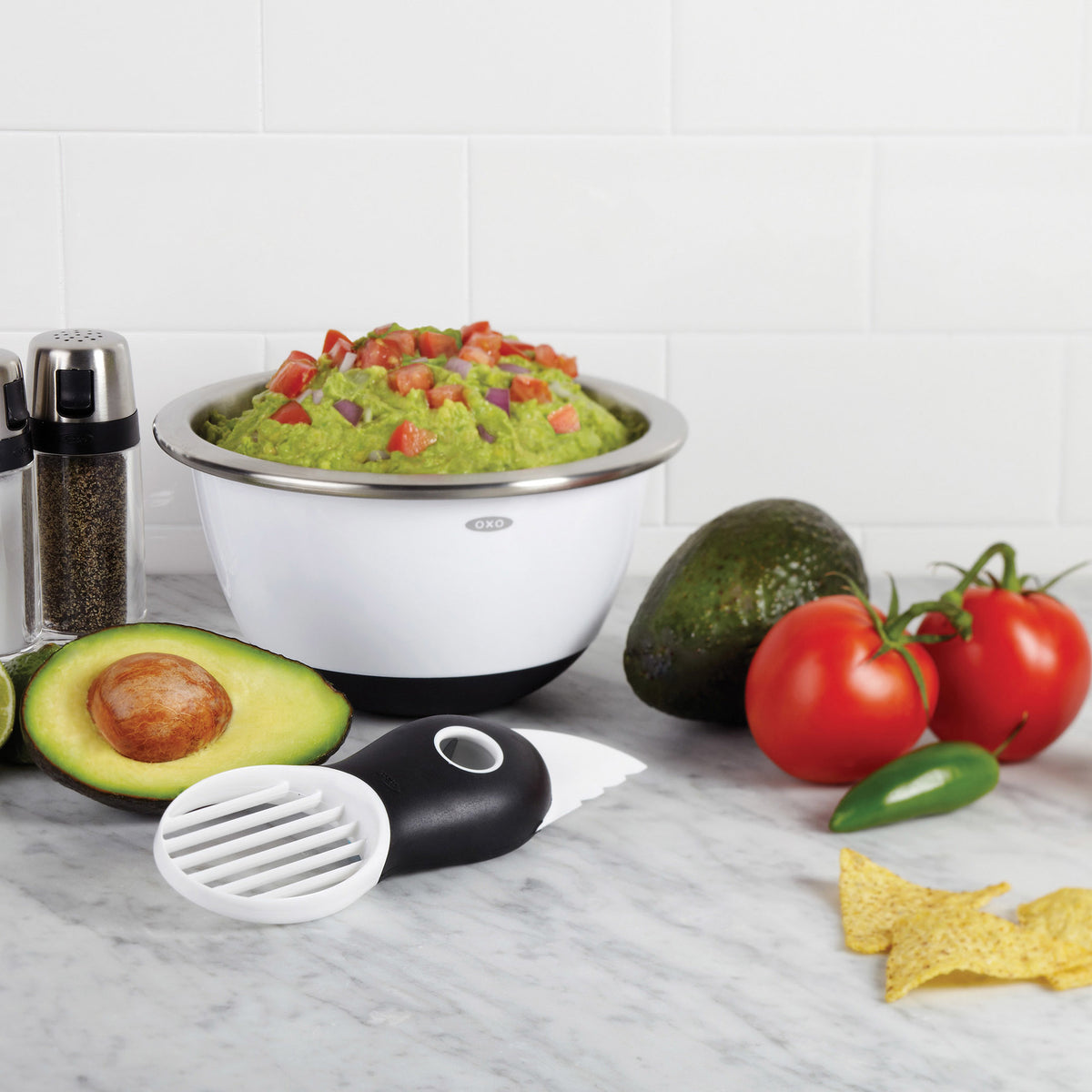 Avocadosnijder 3-in-1 op aanrecht: zwarte greep met witte snij-opzet.