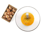 Roterende garde in kom met eiermengsel; draadkloppers zichtbaar