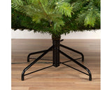 Kunstkerstboom Grandis fir met zichtbare metalen voet op houten vloer
