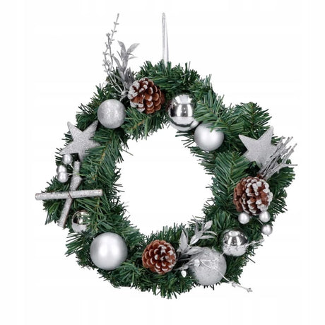 Decoratieve kerstkrans met groene takken, zilveren ballen en dennenappels