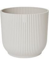Witte ronde plantenpot met verticale ribbels en opstaande rand
