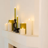 Witte LED-stompkaarsen met warm licht op een plank