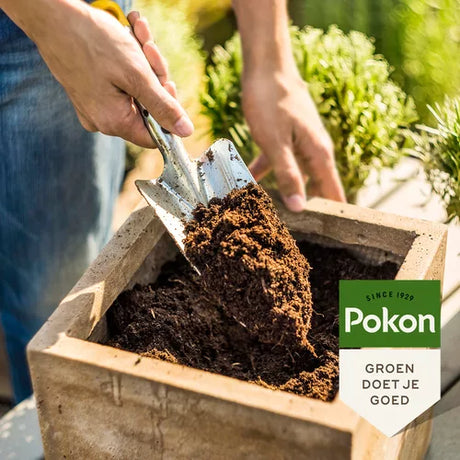 Universele potgrond uitgieten in plantenbak, aangevuld met aarde uit Pokon.