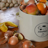 Keukencomposter in crème met COMPOST-logo, open bak met groente- en fruitresten