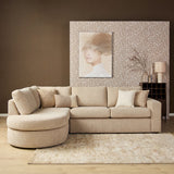Lichtroze hoekbank met chaise en meerdere kussens, ronde zit en zachte textielbekleding