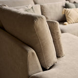 Beige stoffen bankstel met brede armleuningen en sierkussens