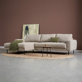 Lichtbeige hoekbank met chaise longue links, sierkussens en groene plaid, zwarte poten