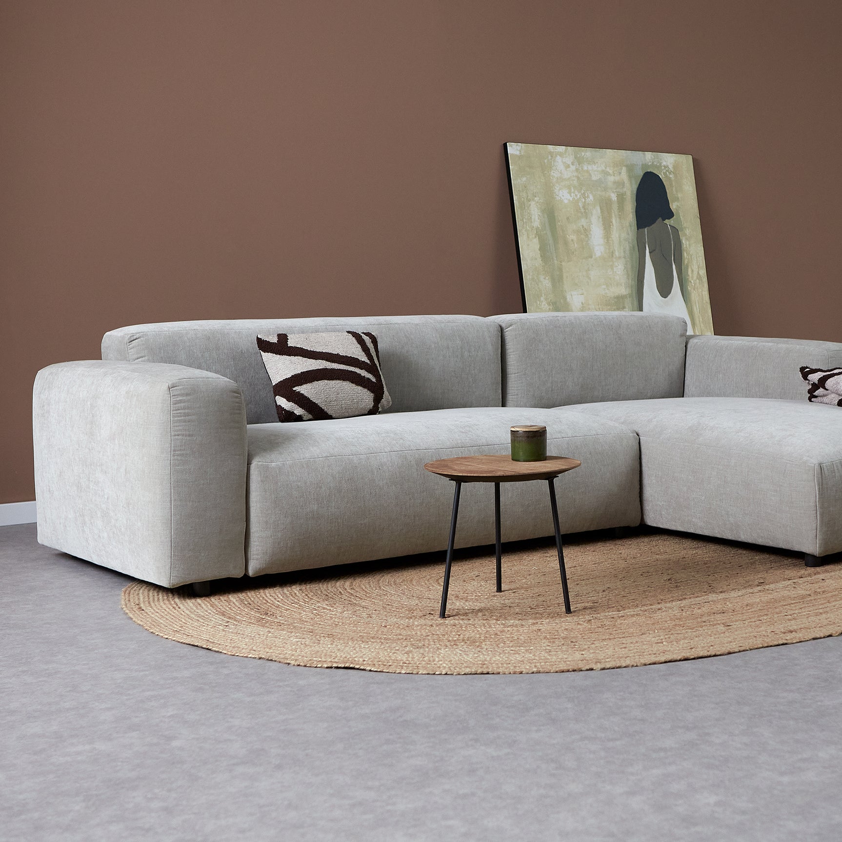 Lichtgrijze hoekbank met chaise rechts, met sierkussens en bijzettafeltje