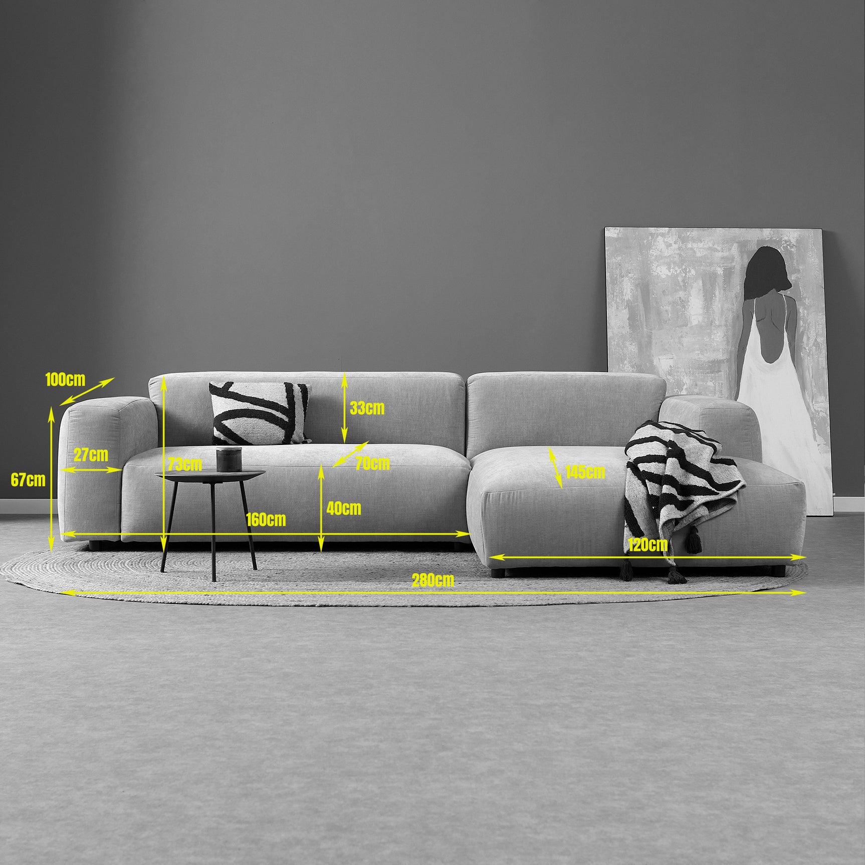 Lichtgrijze chaise longue bank met links uitstekende voetenbank en rugkussens.