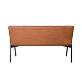 Cognac eetkamerbank met gladde rugbekleding, gevoerde zitting en zwarte metalen poten.