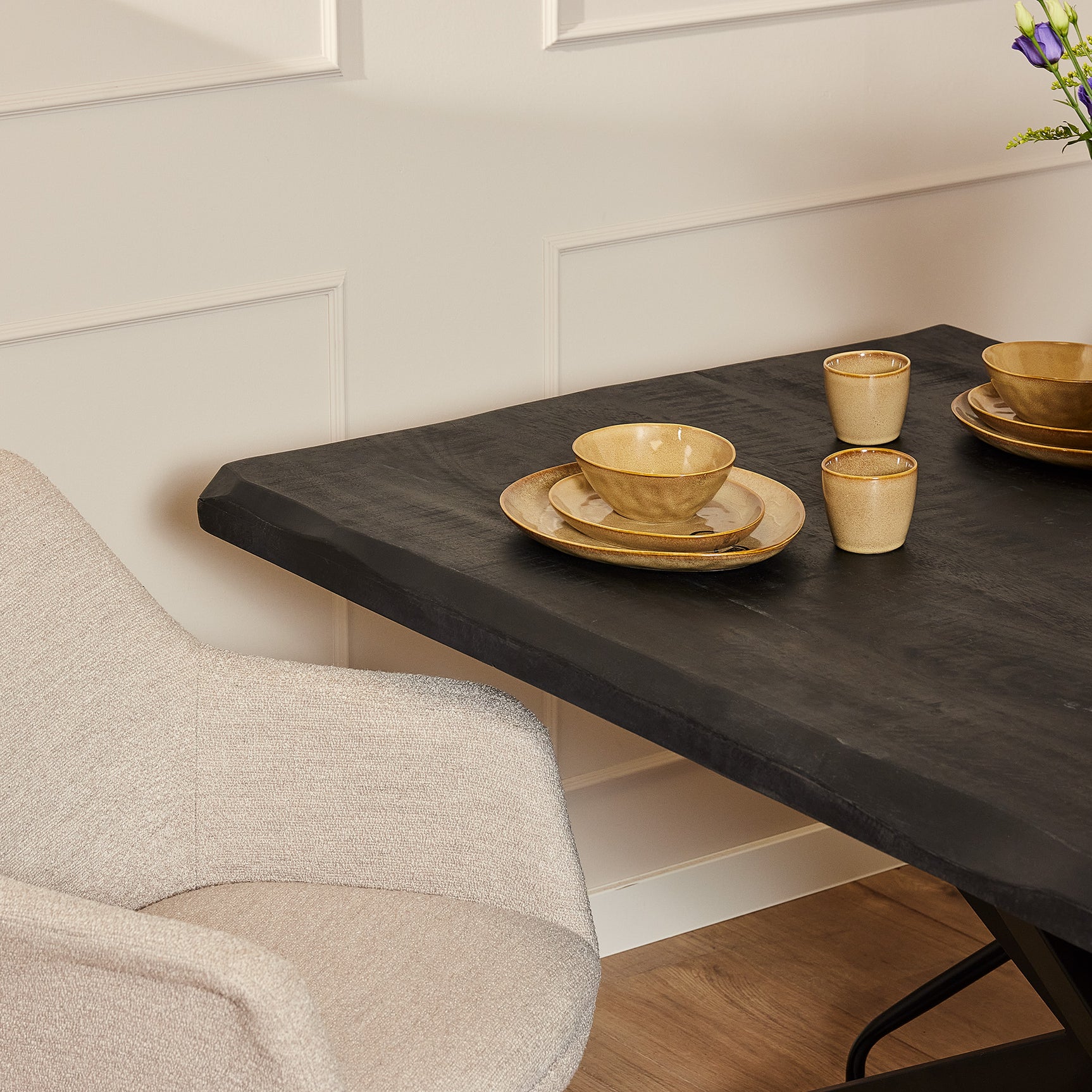Boomstamtafel met donker blad en zwarte kruispoot onder het tafelblad