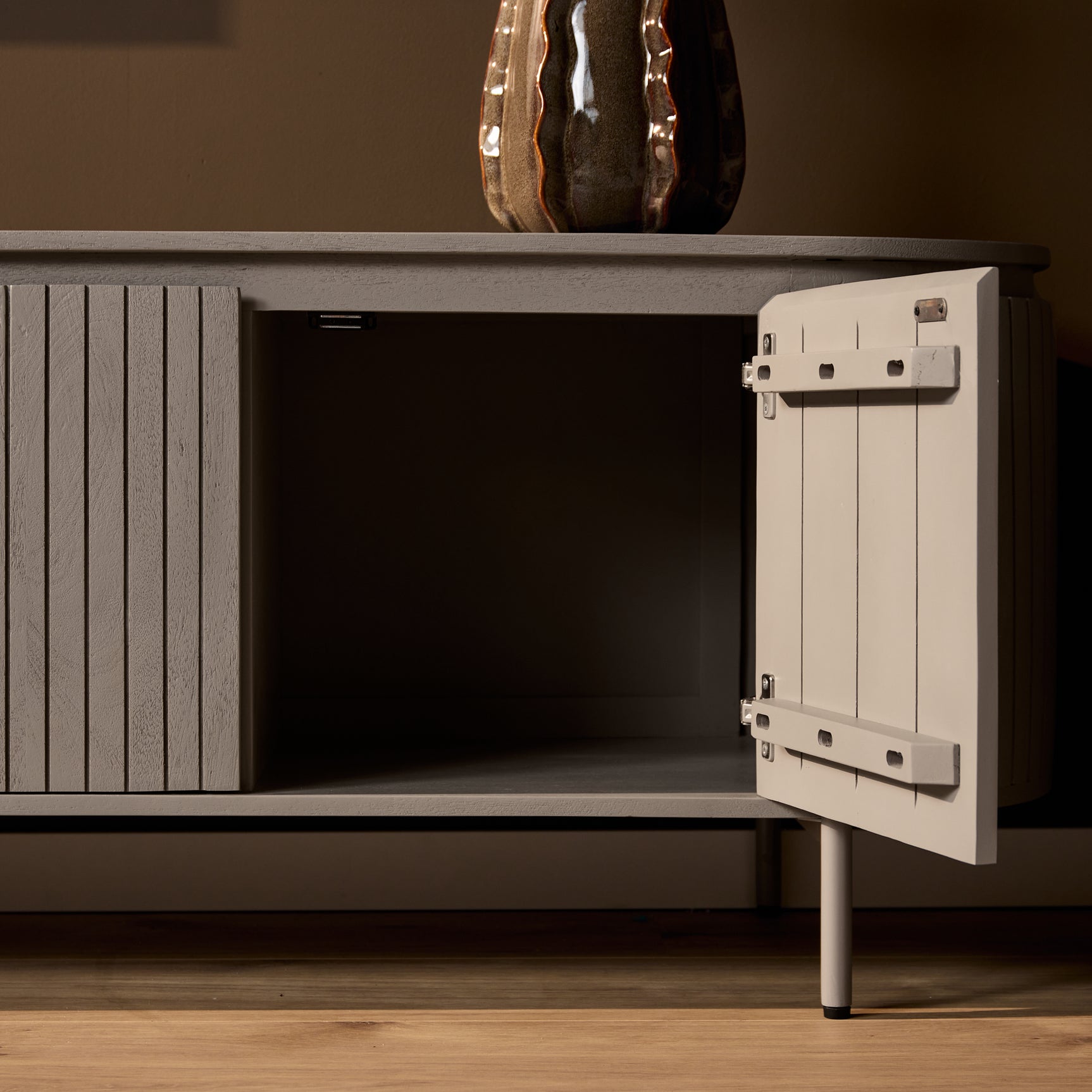 Tv-meubel met open opbergruimte en scharnierende deur, taupe/grijs.