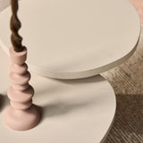Detail van zandkleurig rond tafelblad en gladde ronde voet, twee niveaus