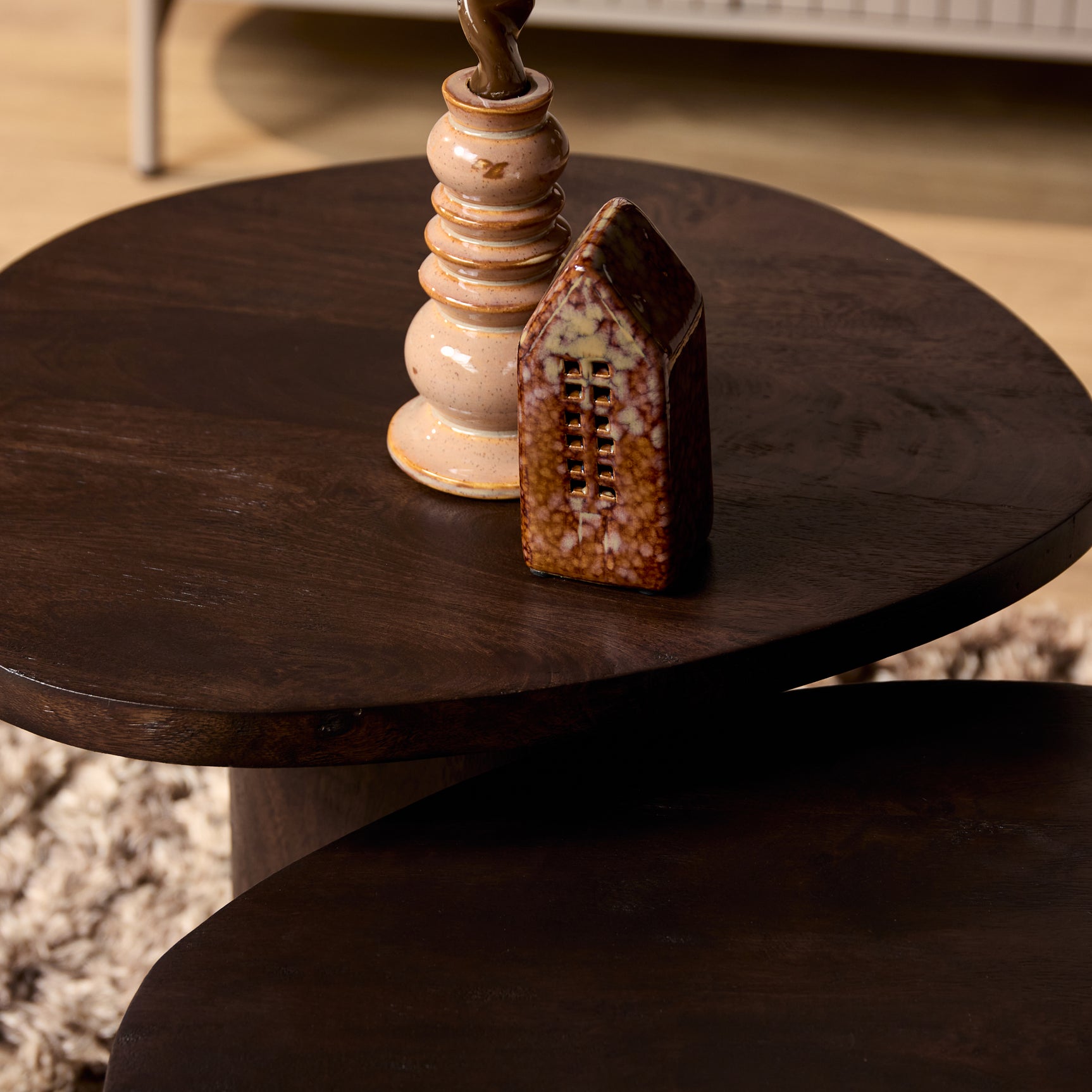 Ronde bruine houten salontafel met dik blad en centrale poot