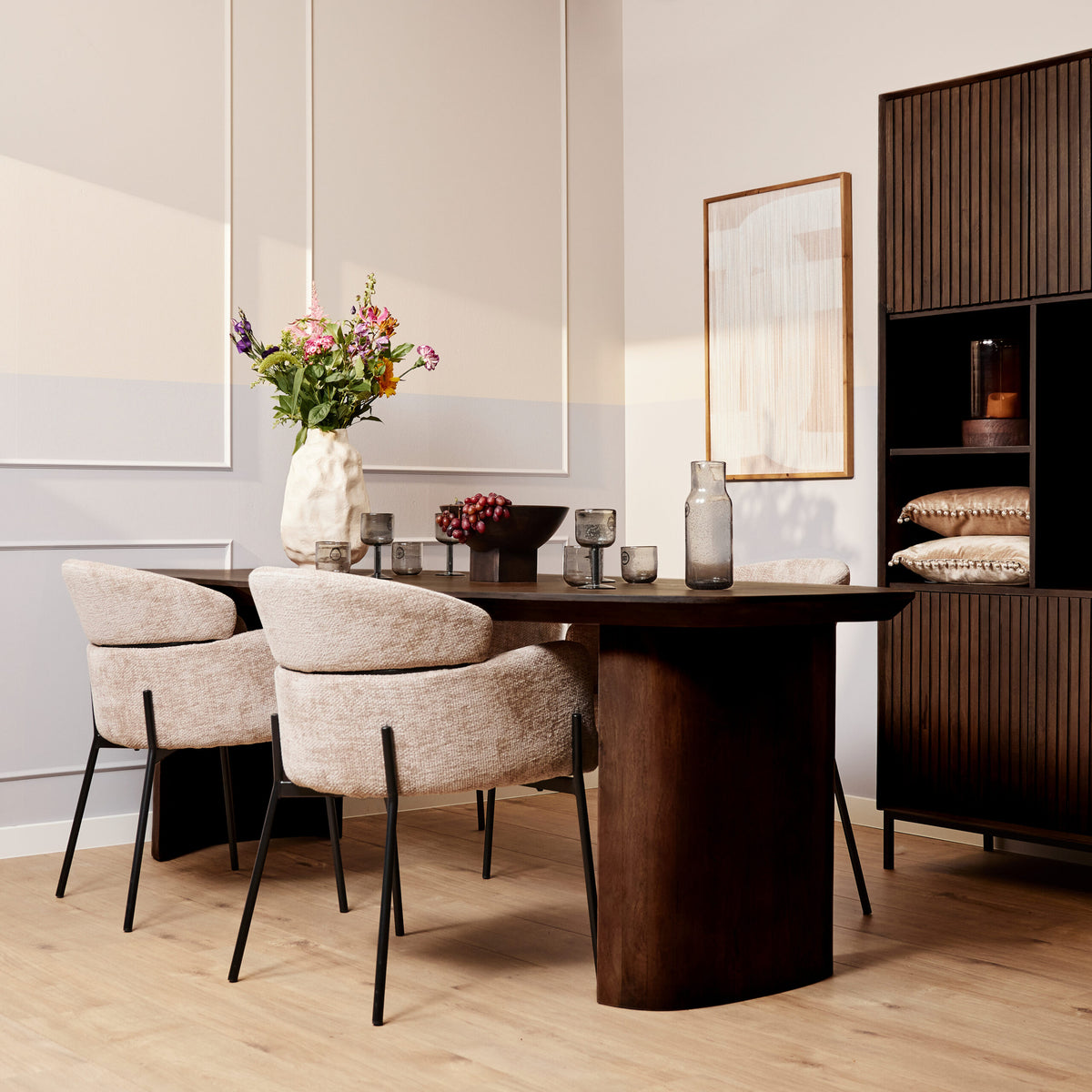 Bruine eettafel in de woonruimte met stoelen eromheen en decoratieve accessoires