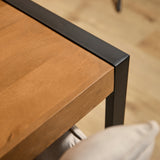 Eettafel hoek met houten blad en zwarte poot, detail van rand en onderzijde.
