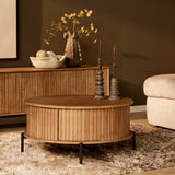 Ronde houten salontafel met ribbenfront en zwart onderstel, naturel blad.