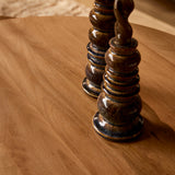 Houten salontafel met kaarsenstandaarden op rond blad.