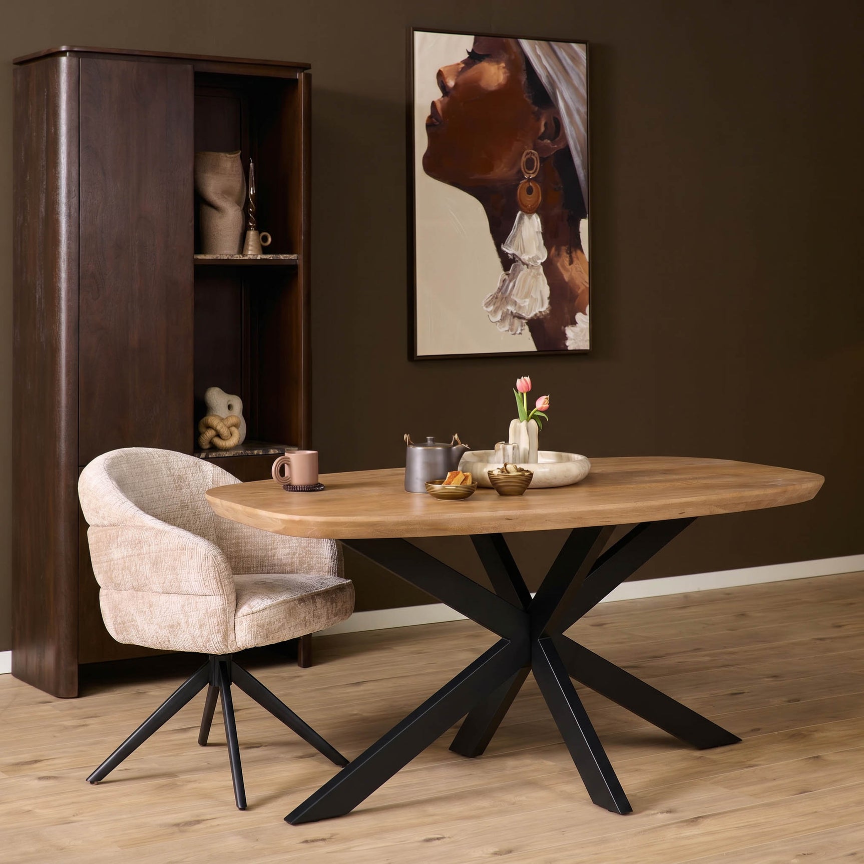 Ovale eettafel met naturel houten blad en zwart kruispoot onderstel.