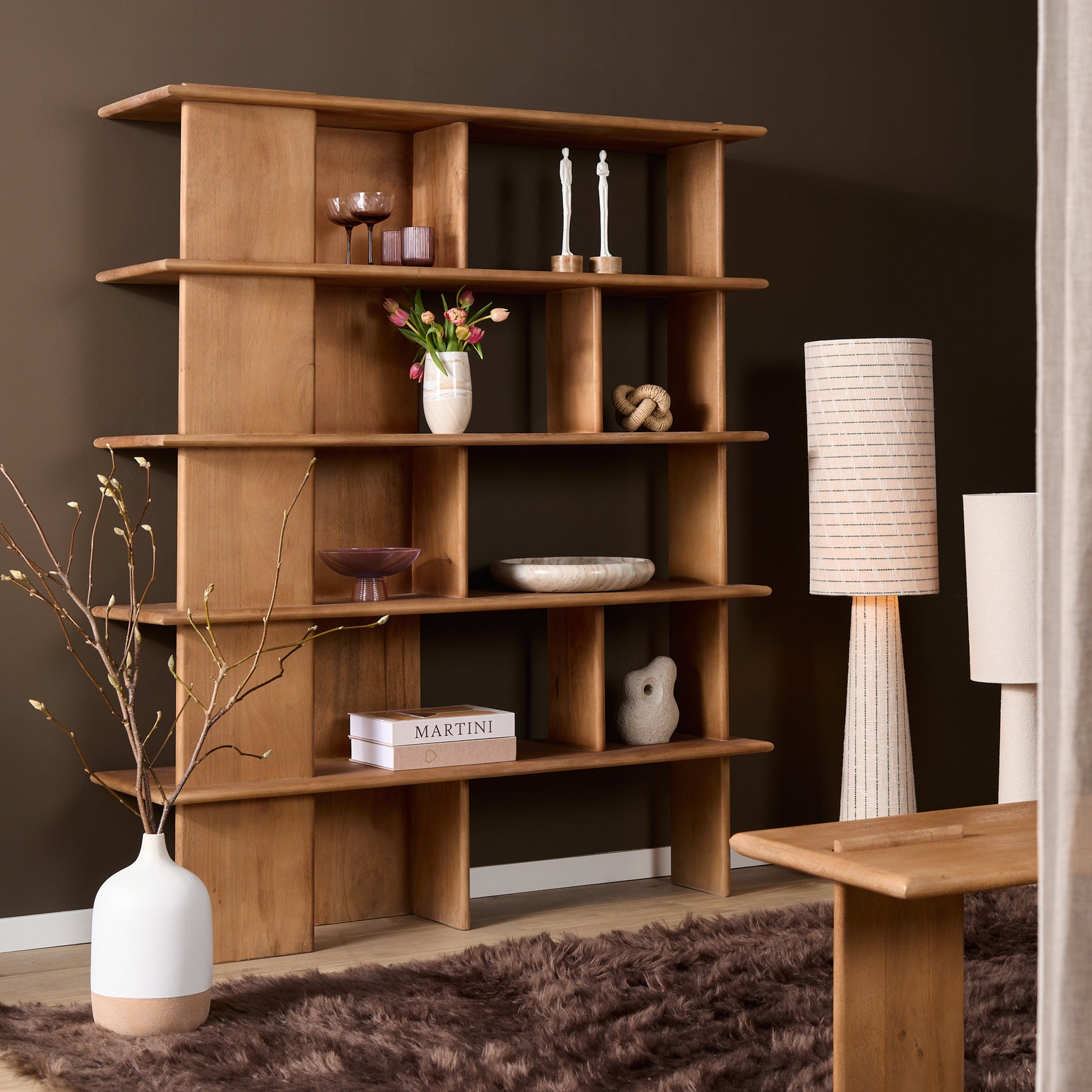 Wandkast met open vakken en legplanken, ingericht met decoratie zoals bloemen en accessoires.