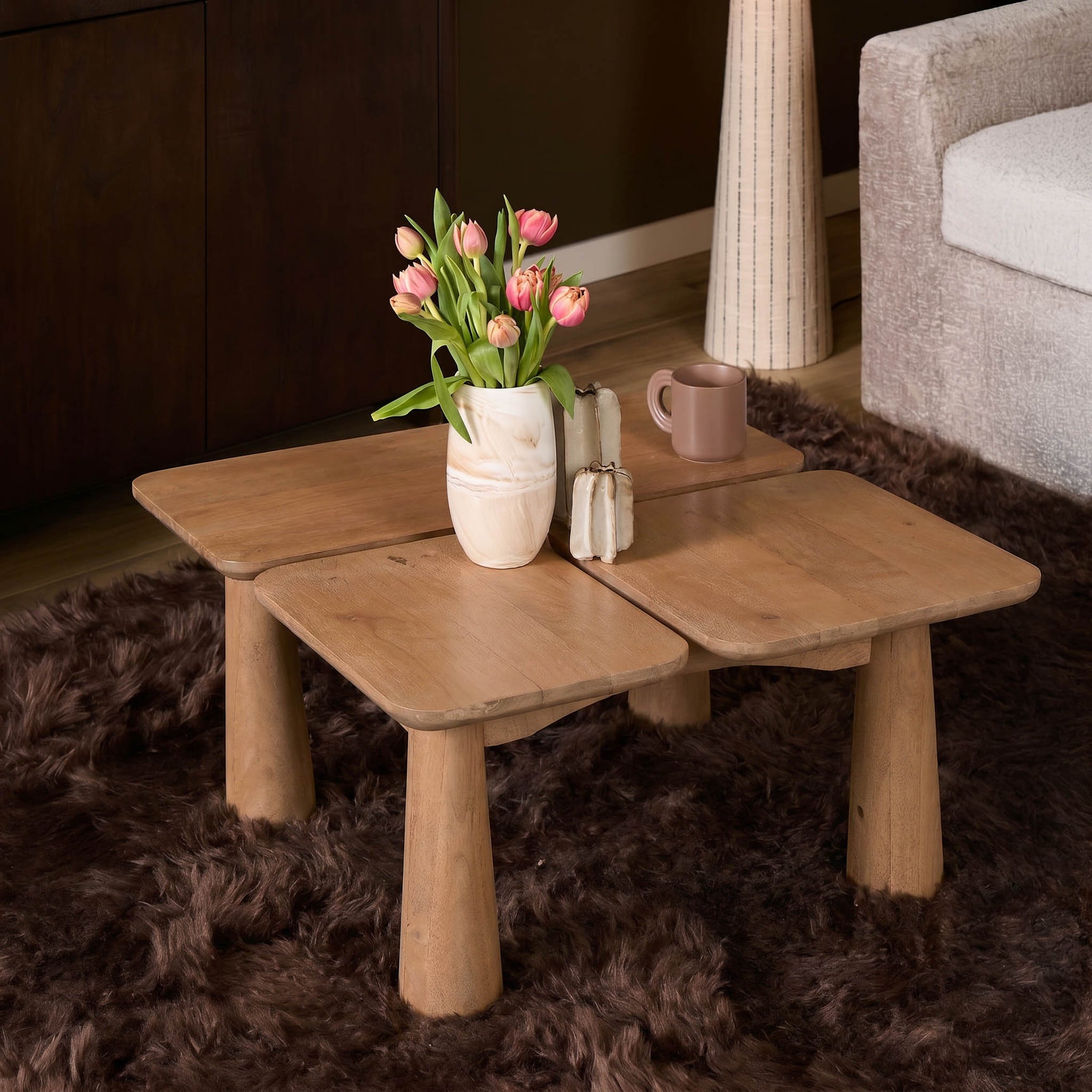 Houten salontafel met vier poten, vaas met bloemen en decor op het blad.