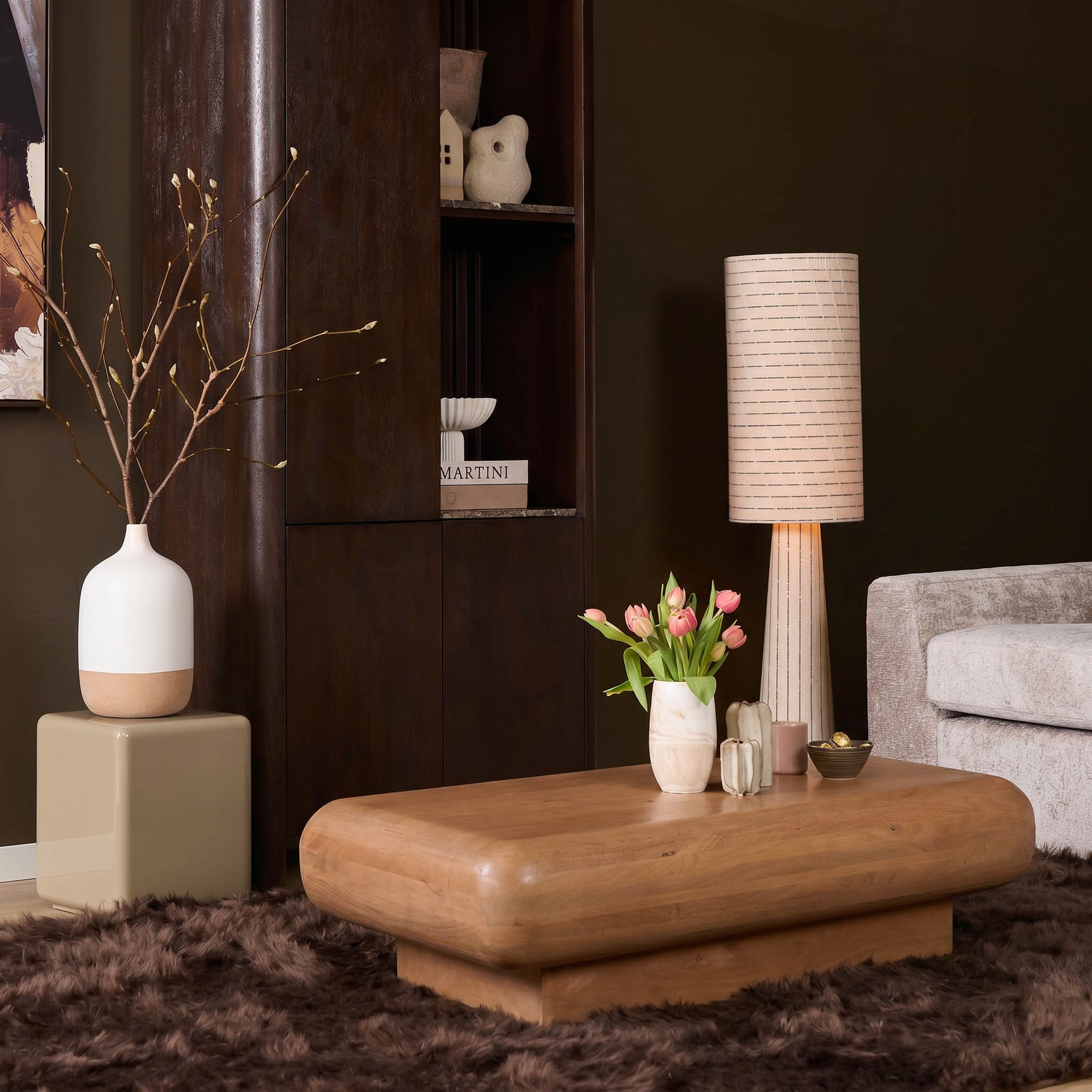Houten salontafel met afgerond blad en laag onderstel in woonsetting
