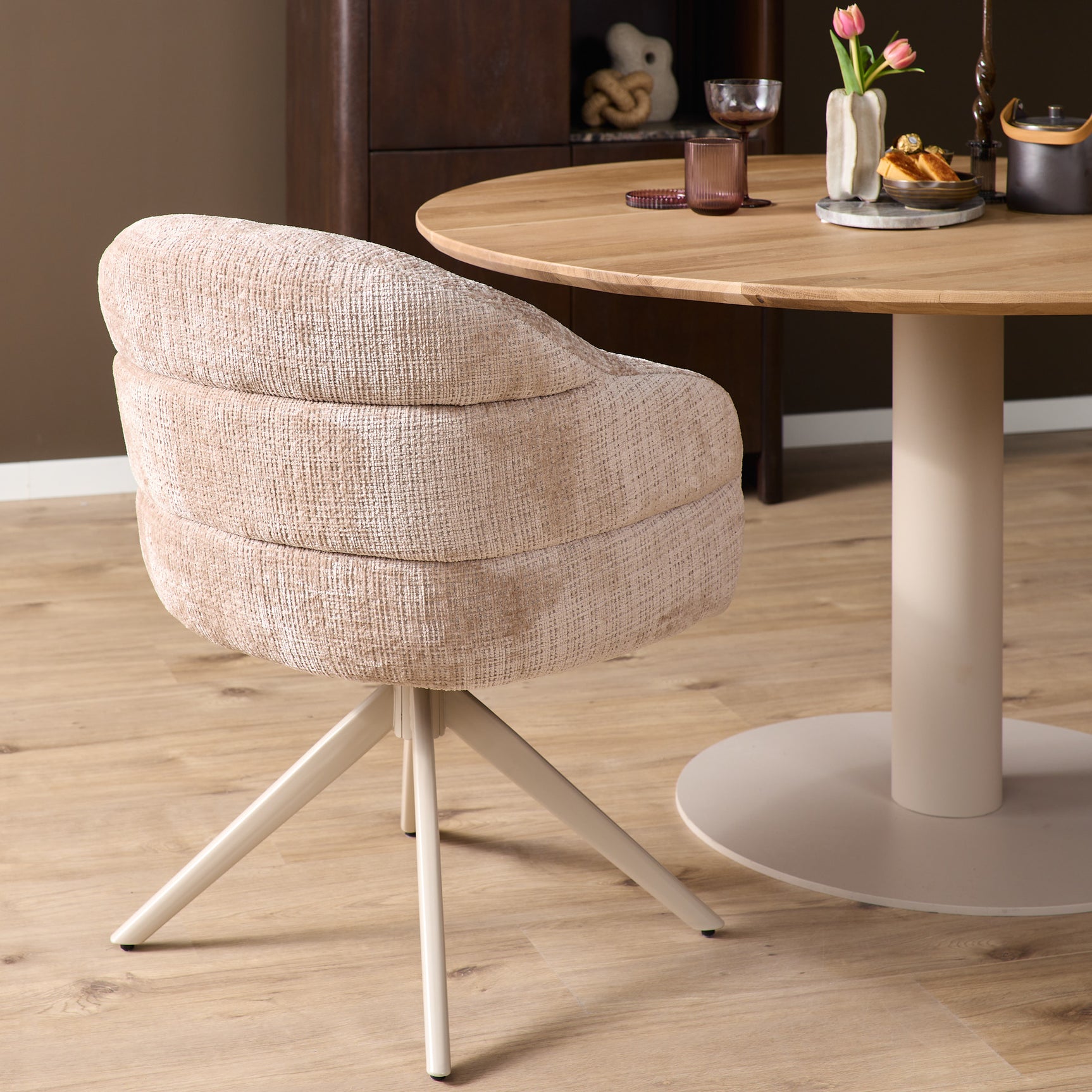 Eetkamerstoel met armleuningen, beige stof en slanke 3-poot constructie in zandkleur