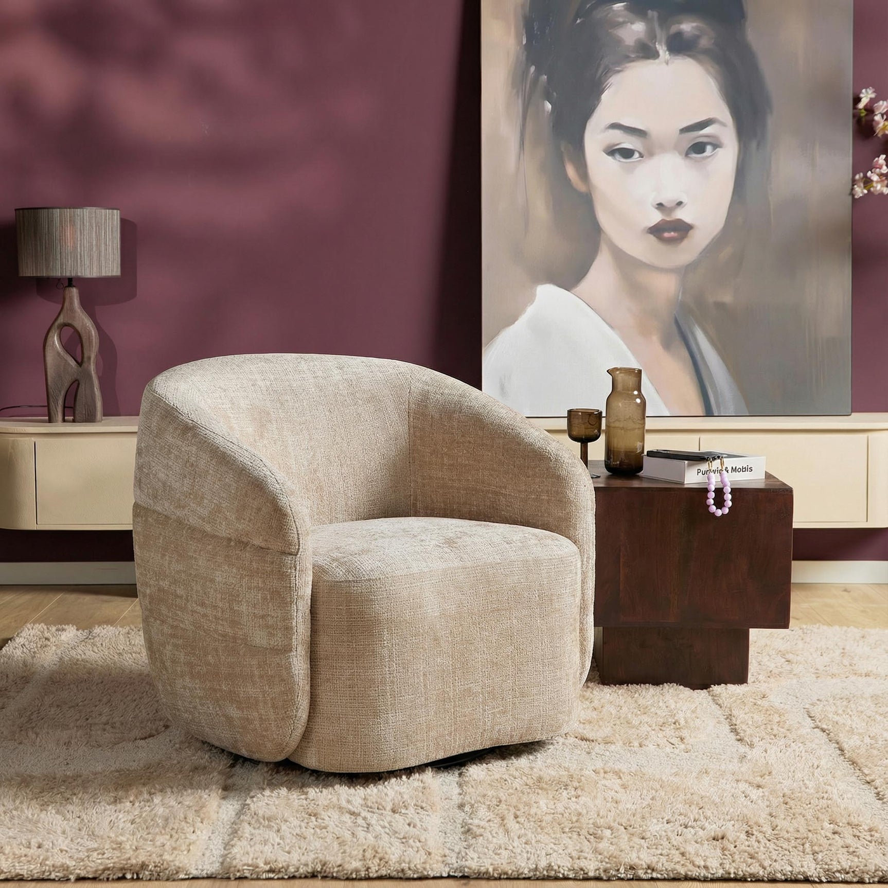 Beige gestoffeerde fauteuil met ronde armleuningen en gedraaide vorm