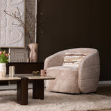 Beige fauteuil met brede armleuningen en ronde zitting, gestoffeerd textiel