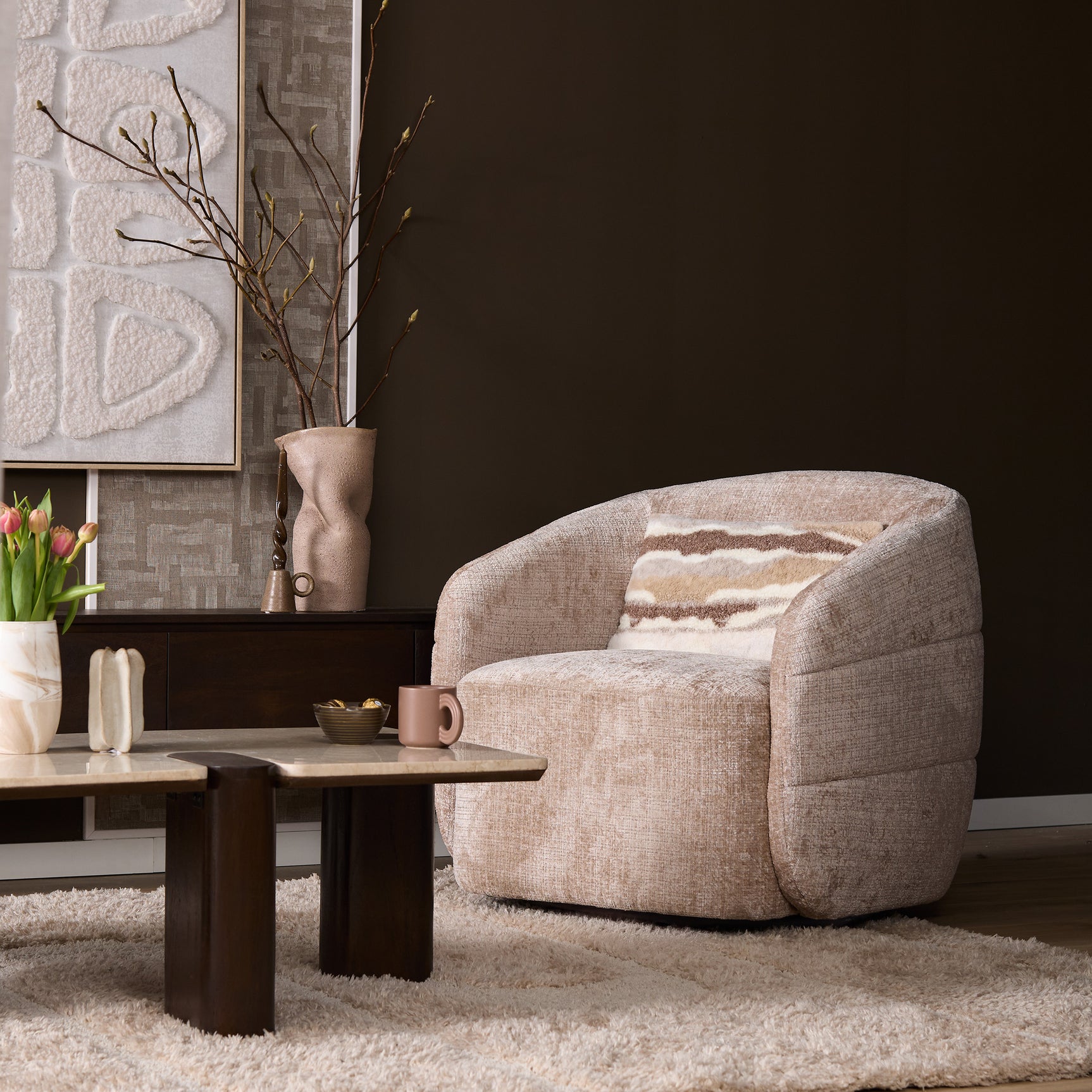 Beige fauteuil met brede armleuningen en ronde zitting, gestoffeerd textiel