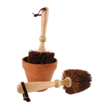 Bloempot borstel met houten steel en ronde borstelharen, bij terracottakleurige pot.