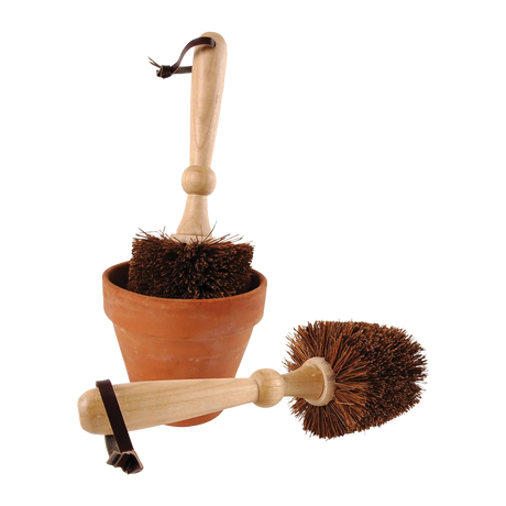 Bloempot borstel met houten steel en ronde borstelharen, bij terracottakleurige pot.