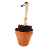 Bloempot borstel met houten steel en borstelharen boven terracottakleurige bloempot.