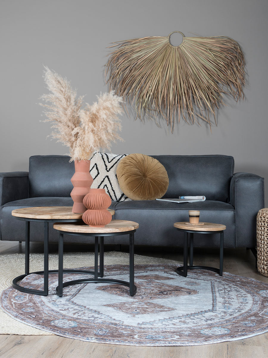 Rond vloerkleed met bruin-beige ornamenten op lichte basis.