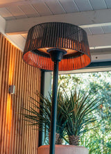 Bovenaanzicht van terrasverwarmer: ronde kap met zichtbare brander en zwarte voet.