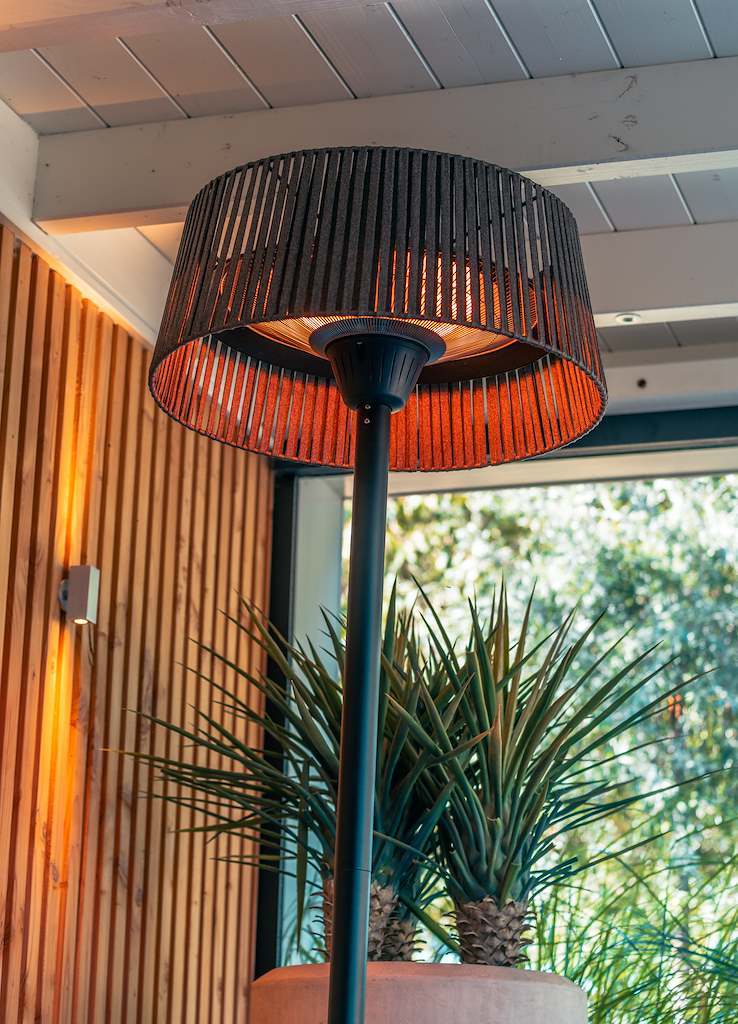 Bovenaanzicht van terrasverwarmer: ronde kap met zichtbare brander en zwarte voet.