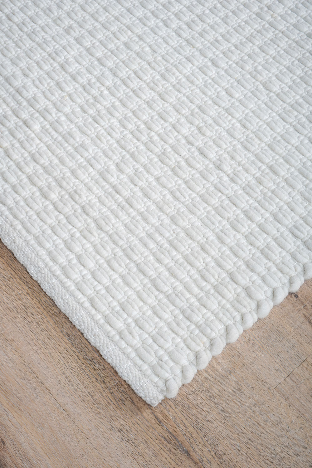 Vloerkleed Nicole crème: close-up van geribbelde, lichtcrème pool en rand