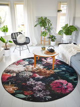Rond vloerkleed met grote bloemen in roze, blauw en wit op donkere basis