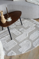 Rond vloerkleed met grijs-beige ingelegd patroon en korte, zachte pool.