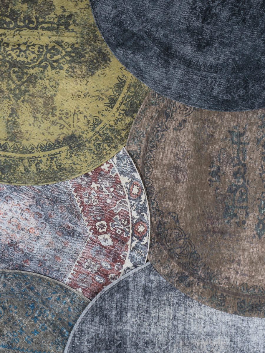 Rond vloerkleed in grijsblauwe tint met decoratief oosters patroon, zichtbaar deel