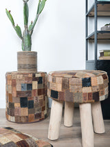 Ronde poef met patchwork labels in bruine en blauwe tinten, op houten pootjes